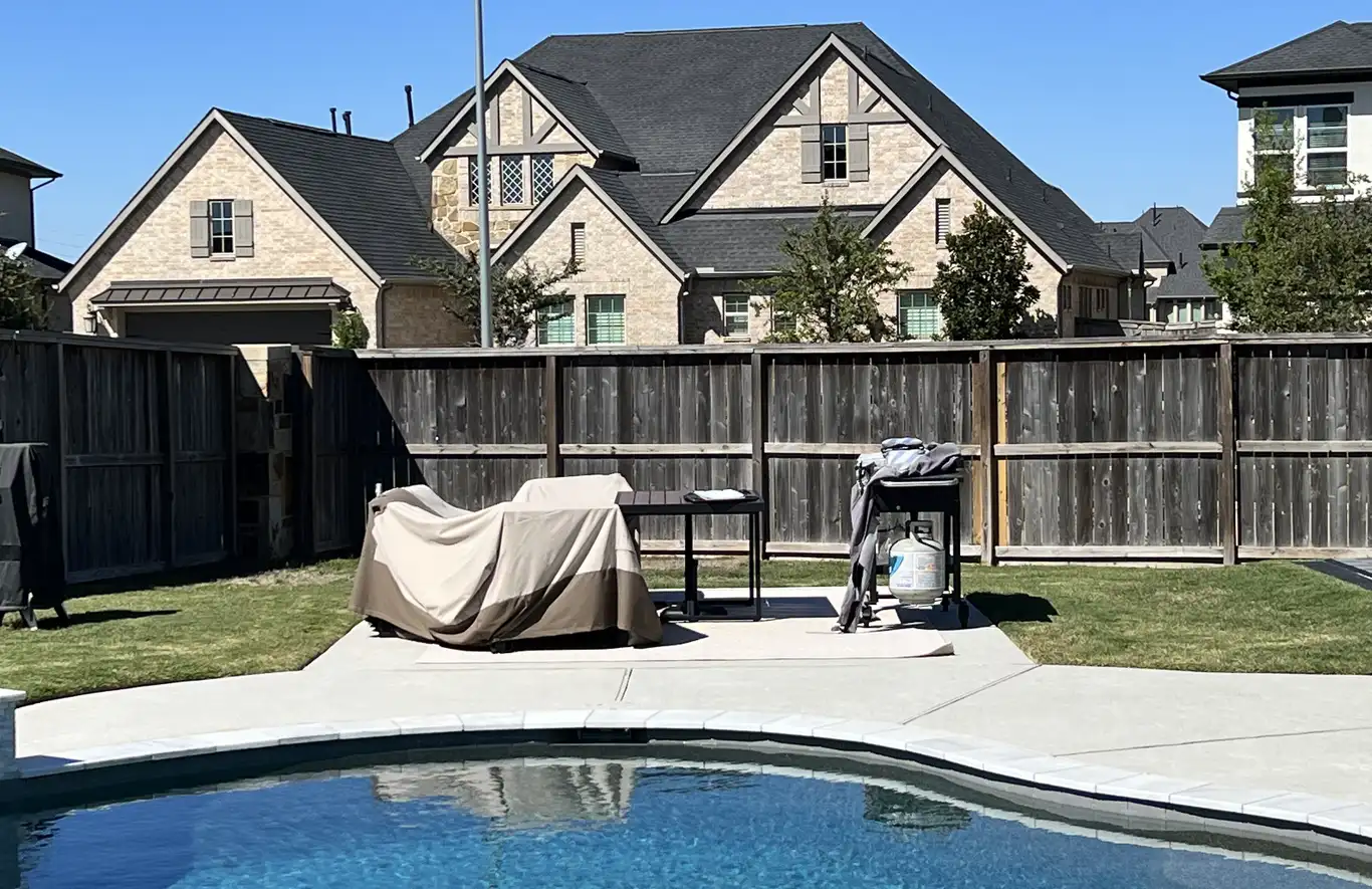 Before: plain concrete pool deck with a small covered grill and patio furniture against a wood fence