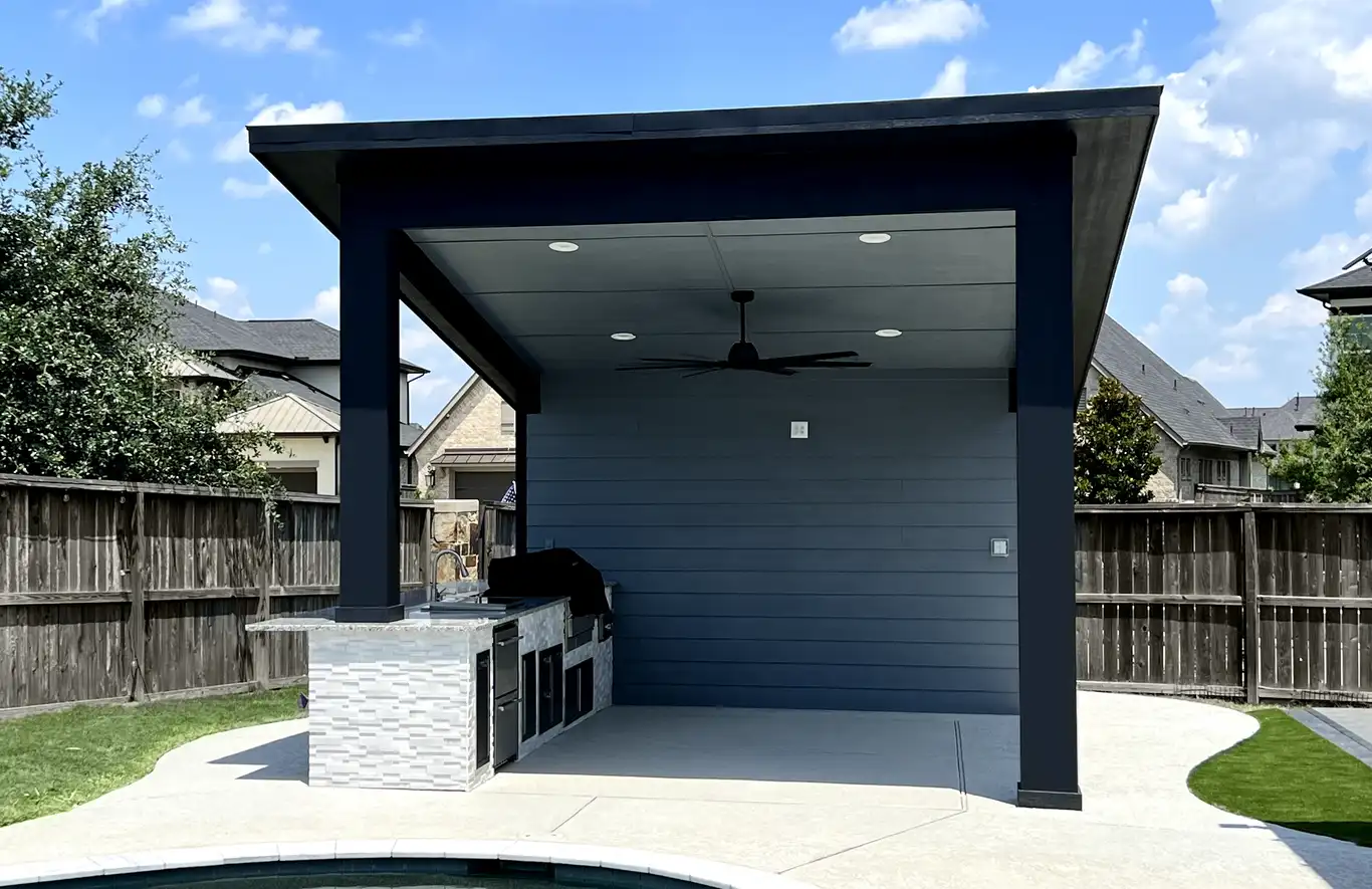 After: modern freestanding pavilion with ceiling fan, recessed lights and a stone-clad grill island by the pool