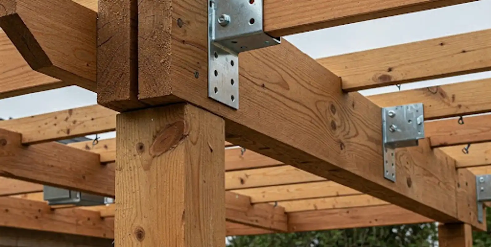 Close-up of cedar post and beam framing with galvanized steel brackets during construction
