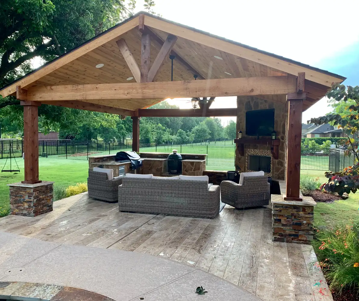 Freestanding cedar gable pavilion with stone column bases, fireplace and outdoor seating