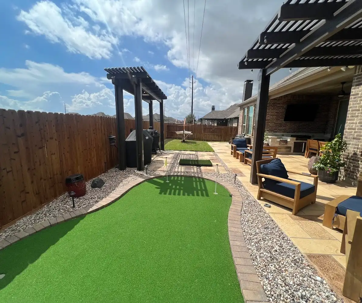 Cedar pergola and patio seating beside an artificial turf putting green