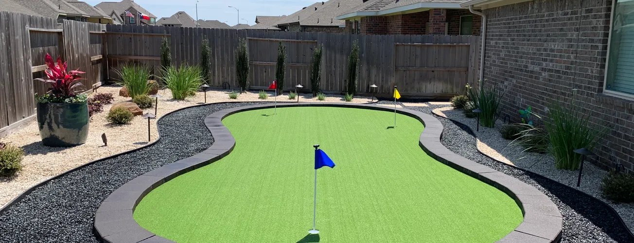 Artificial turf putting green with flags and a curb border in a Houston backyard
