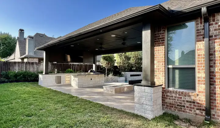 Patio cover with stone columns, outdoor kitchen and fire feature on a travertine patio