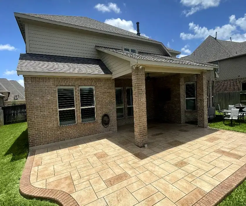Stamped concrete patio with an ashlar pattern and contrasting border in a Houston backyard