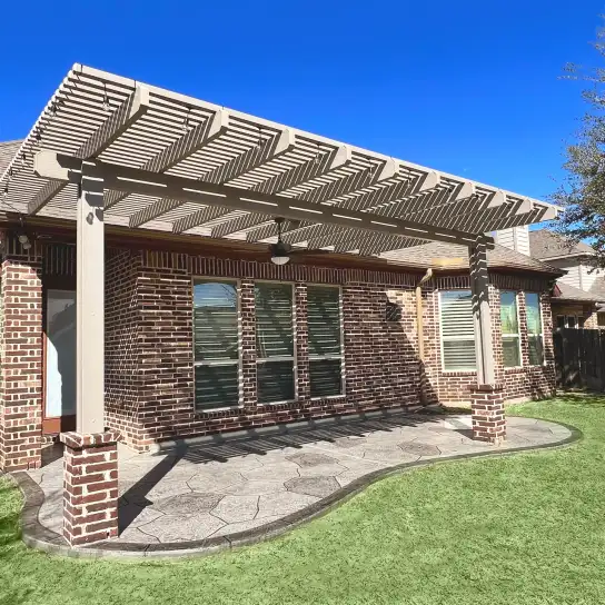 Painted pergola on brick columns over a stamped concrete patio with artificial turf