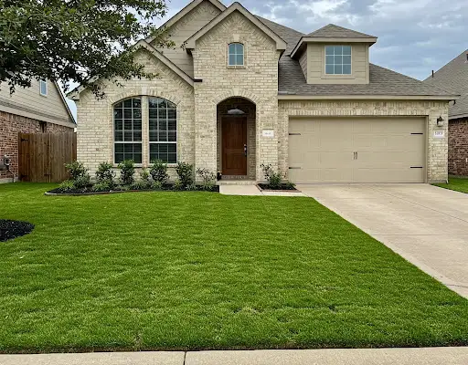 Thick, newly sodded front lawn at a two-story brick home