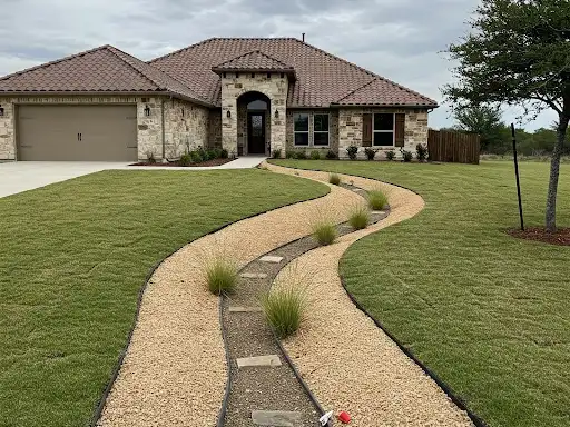 Decomposed granite path with stepping stones and ornamental grasses leading to a home