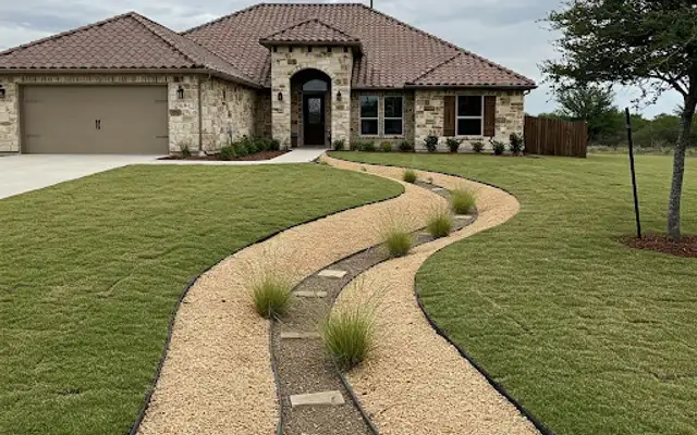 Winding gravel path with stepping stones and ornamental grasses across a front lawn