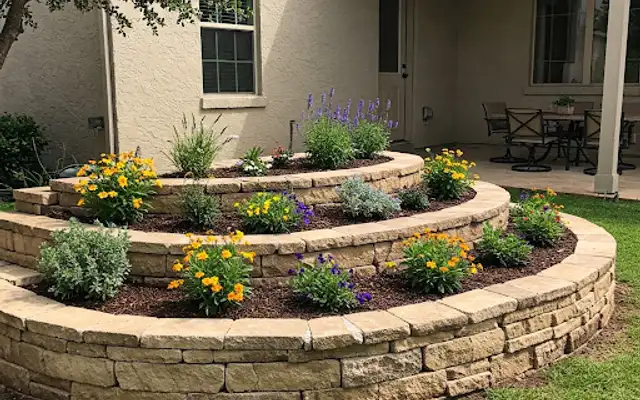 Three-tier curved stone retaining wall planted with yellow and purple flowers
